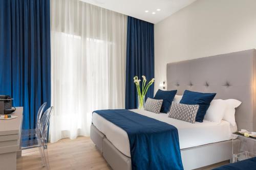 a hotel room with a large bed with blue curtains at Residenza Zanardelli in Rome