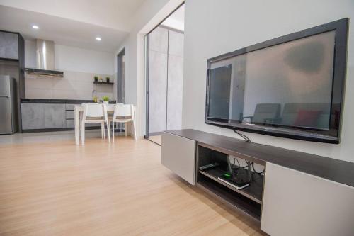 a living room with a large flat screen tv on a wall at USJ One HomeStay @ Subang HomeStay in Subang Jaya