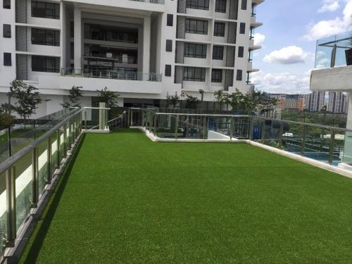 a balcony with green grass in front of a building at USJ One HomeStay @ Subang HomeStay in Subang Jaya