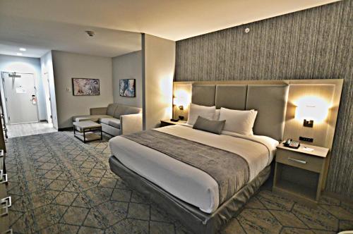 a hotel room with a large bed and a chair at Best Western Plus Executive Residency Oklahoma City I-35 in Oklahoma City