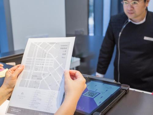 a person holding up a piece of paper and a tablet at The Place Taichung in Taichung