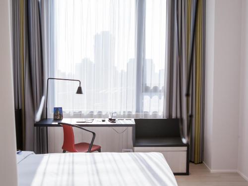 a bedroom with a desk and a chair next to a window at The Place Taichung in Taichung