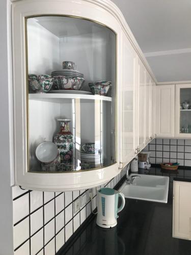 a kitchen with a sink and a cabinet with dishes at Nitsa Rooms in Kos