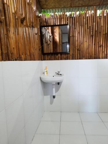 uma casa de banho com um lavatório e um espelho em Mojosurf Camp Red Island em Pasanggaran