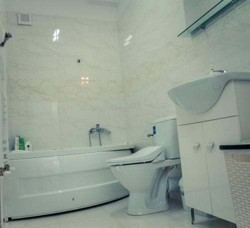 a bathroom with a toilet and a tub and a sink at Apartament #LUNA MAMAIA N in Mamaia Nord