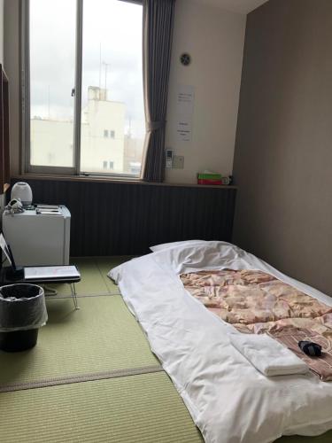 Postel nebo postele na pokoji v ubytování Hotel Tetora Asahikawa Station
