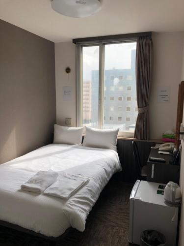 Un pat sau paturi într-o cameră la Hotel Tetora Asahikawa Station