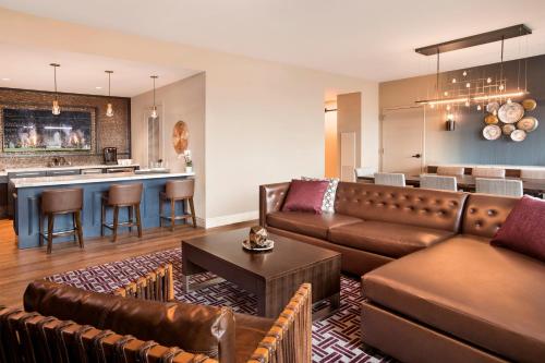 a living room with a couch and a kitchen at Texas A&M Hotel and Conference Center in College Station