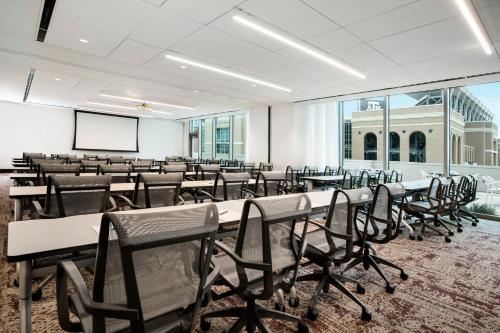 a conference room with tables and chairs and a screen at Texas A&M Hotel and Conference Center in College Station
