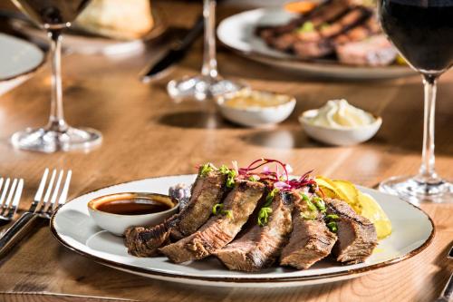 a table with plates of food and glasses of wine at Texas A&M Hotel and Conference Center in College Station