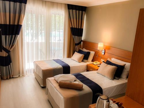 a hotel room with two beds and a window at Master Family Club in Manavgat