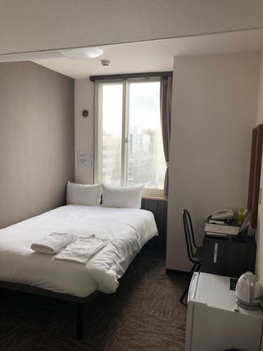 Postel nebo postele na pokoji v ubytování Hotel Tetora Asahikawa Station