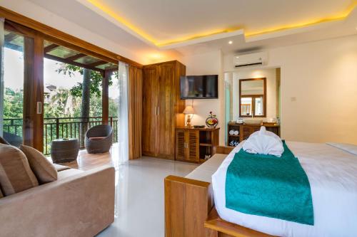 a bedroom with a bed and a couch at The Pesaren Ubud in Ubud