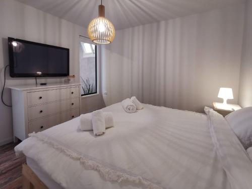 a white bedroom with a large bed with towels on it at Eilat vacation house דירות נופש אילת in Eilat