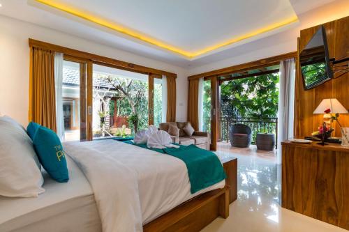 a bedroom with a large bed and a television at The Pesaren Ubud in Ubud