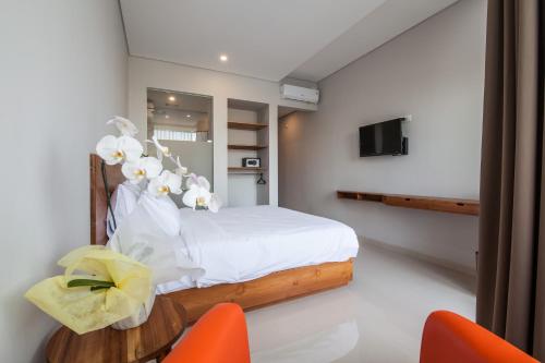 a bedroom with a bed and a table and chairs at Eclipse Kerobokan in Kerobokan