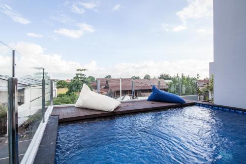 a pool on the roof of a building with pillows at Eclipse Kerobokan in Kerobokan