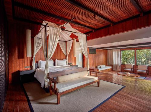 a bedroom with a bed with a canopy at Taj Exotica Resort & Spa, Andamans in Havelock Island