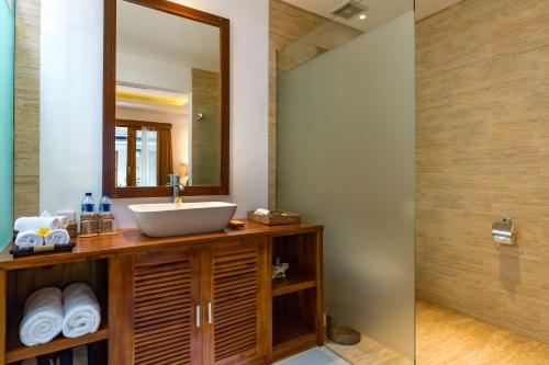 a bathroom with a sink and a mirror at The Pesaren Ubud in Ubud