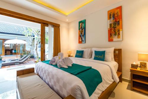 a bedroom with a large bed and a large window at The Pesaren Ubud in Ubud