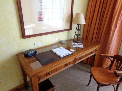 a desk in a room with a mirror and a telephone at Park Hotel Calama in Calama