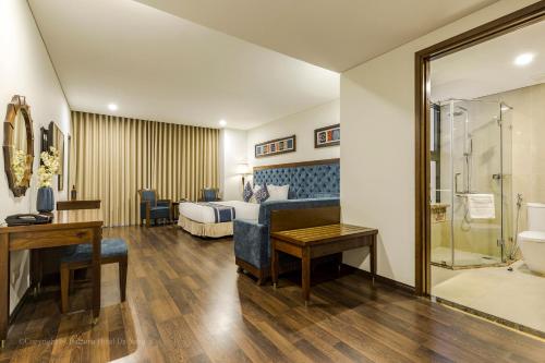 a hotel room with a bed and a bathroom at Balcona Hotel Da Nang in Da Nang