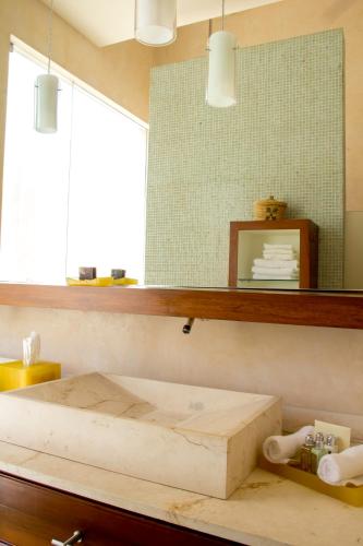 a bedroom with a bed and a mirror at Rosas & Xocolate Boutique Hotel and Spa Merida, a Member of Design Hotels in Mérida