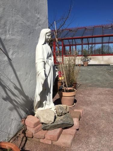 a statue of a woman sitting on a wall at Kastanjegården på Stenshuvud in Kivik