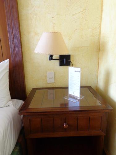 a table with a lamp and a laptop on it at Park Hotel Calama in Calama