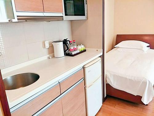 a small kitchen with a sink and a bed at East King Business Hotel (West Lake store, Hangzhou) in Hangzhou