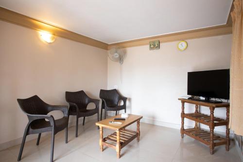 a room with chairs and a table and a tv at Casa Margarida in Calangute