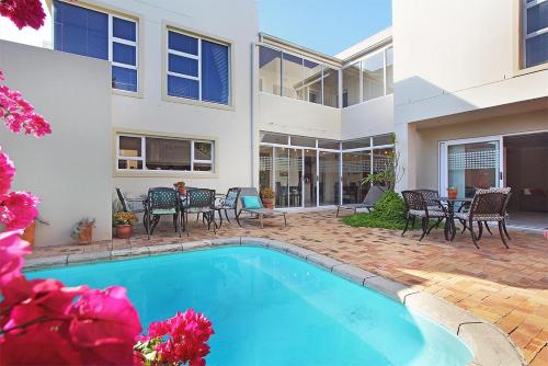 a swimming pool in front of a house at Atlantic Breeze in Cape Town