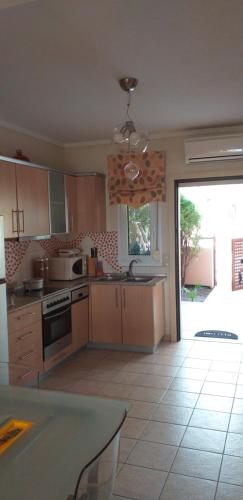 a kitchen with wooden cabinets and a large window at Magic Mola in Mola Kalyva