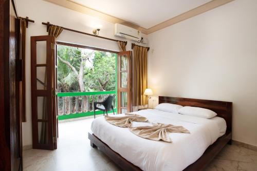 a bedroom with a bed and a large window at Casa Margarida in Calangute