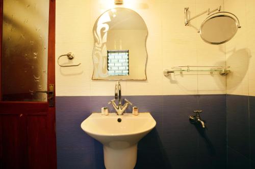a bathroom with a sink and a mirror at Casa Margarida in Calangute