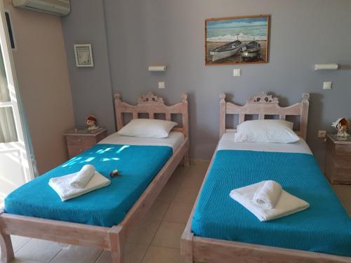 Livadi AstypalaiasにあるKarabo Hotelのベッド2台が隣同士に設置された部屋です。