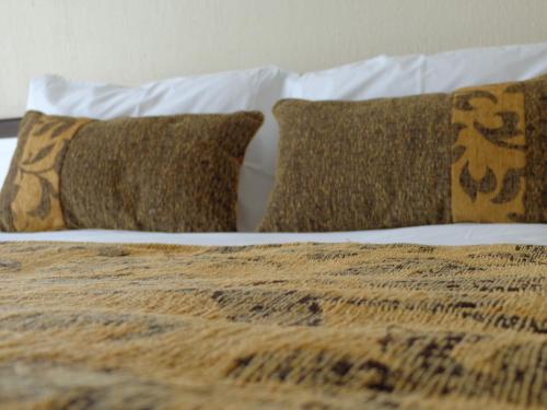 a bed with two pillows and a blanket at Park Hotel Calama in Calama