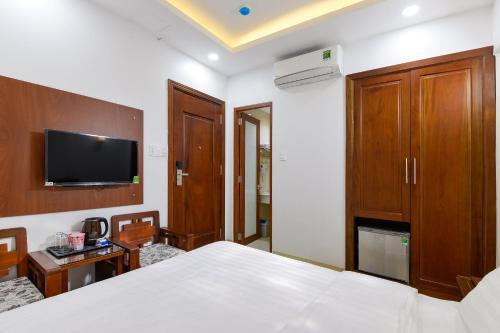 ein Hotelzimmer mit einem Bett und einem TV in der Unterkunft Royal Hotel in Ho-Chi-Minh-Stadt