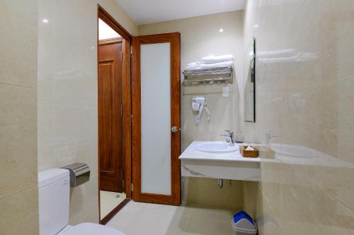 La salle de bains blanche est pourvue d'un lavabo et de toilettes. dans l'établissement Royal Hotel, à Hô-Chi-Minh-Ville