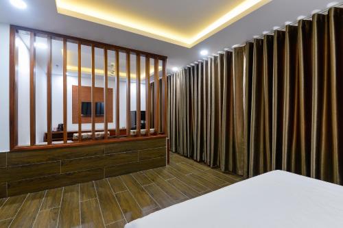 a room with large curtains and a television in it at Royal Hotel District 2 in Ho Chi Minh City