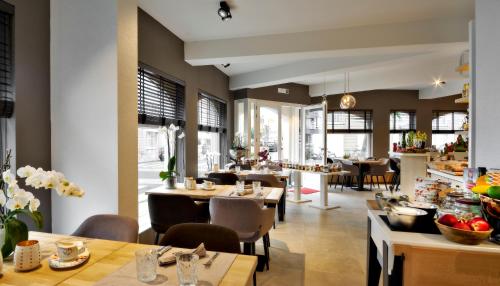 un restaurant avec des tables et des chaises et une cafétéria dans l'établissement ABC Hotel, à Blankenberge
