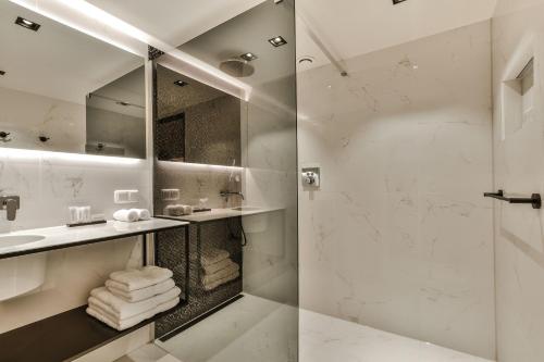 a bathroom with a shower and a sink at Luxury Canal Suite De Heren in Amsterdam