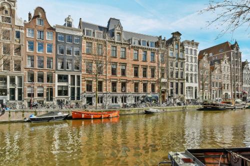 a canal in a city with buildings and boats in it at Luxury Canal Suite De Heren in Amsterdam