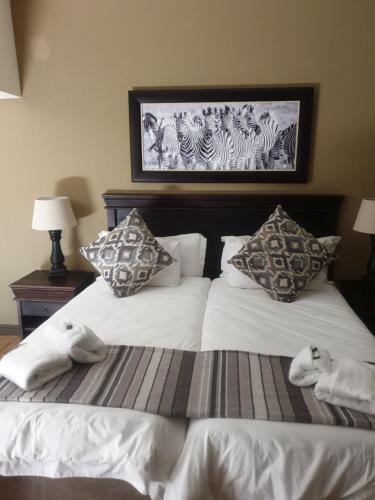 a bedroom with two beds with towels on them at Nkomazi Kruger Lodge & Spa in Malelane