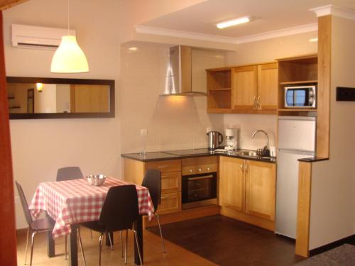 a kitchen with a table with a tablecloth on it at Apartamentos Kósmos in Horta