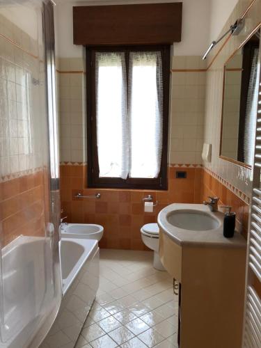 a bathroom with a tub and a toilet and a sink at Veneto Civico 17 in Sarnico