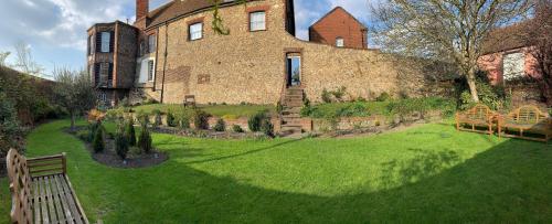 a large brick building with a lawn in front of it at Castle House Hotel in Canterbury