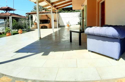 a patio with a couch sitting on a tile floor at Tsina’s apartments in Ágios Nikólaos