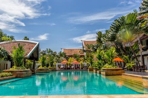 a swimming pool in front of a resort at Mission Hills Phuket Golf Resort-SHA Extra Plus in Por Bay