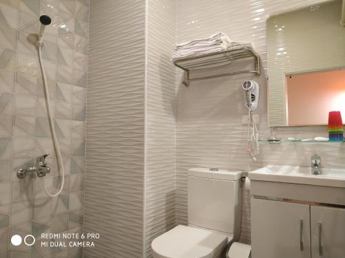 a bathroom with a toilet and a sink and a shower at Sun Moon Lake Crown Yu Hotel in Yuchi